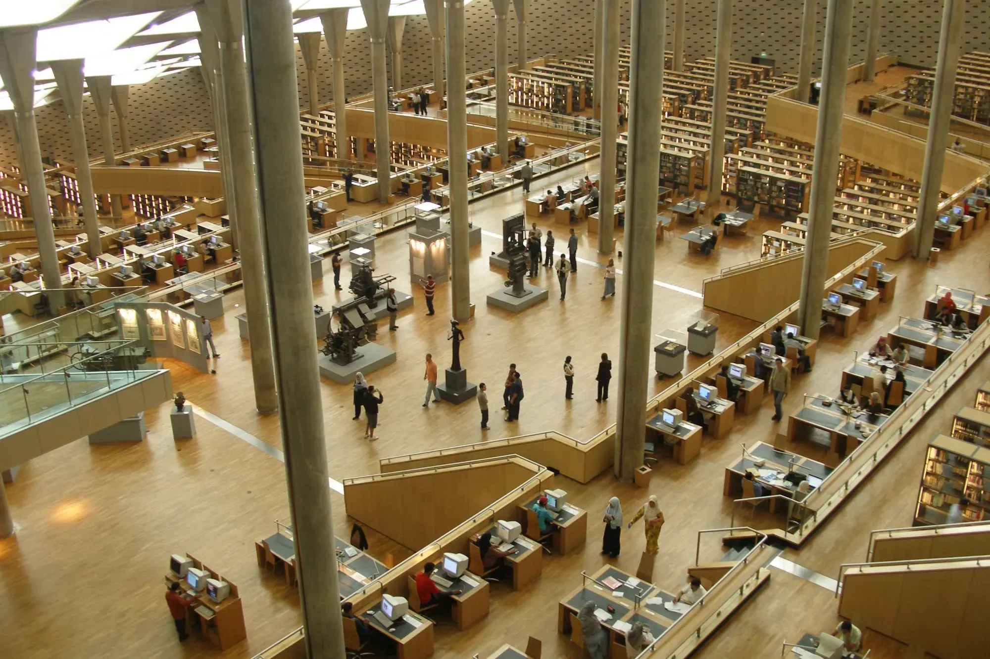The main reading room seen from above: terraced floors of desks among slender columns, lit by skylights in the roof