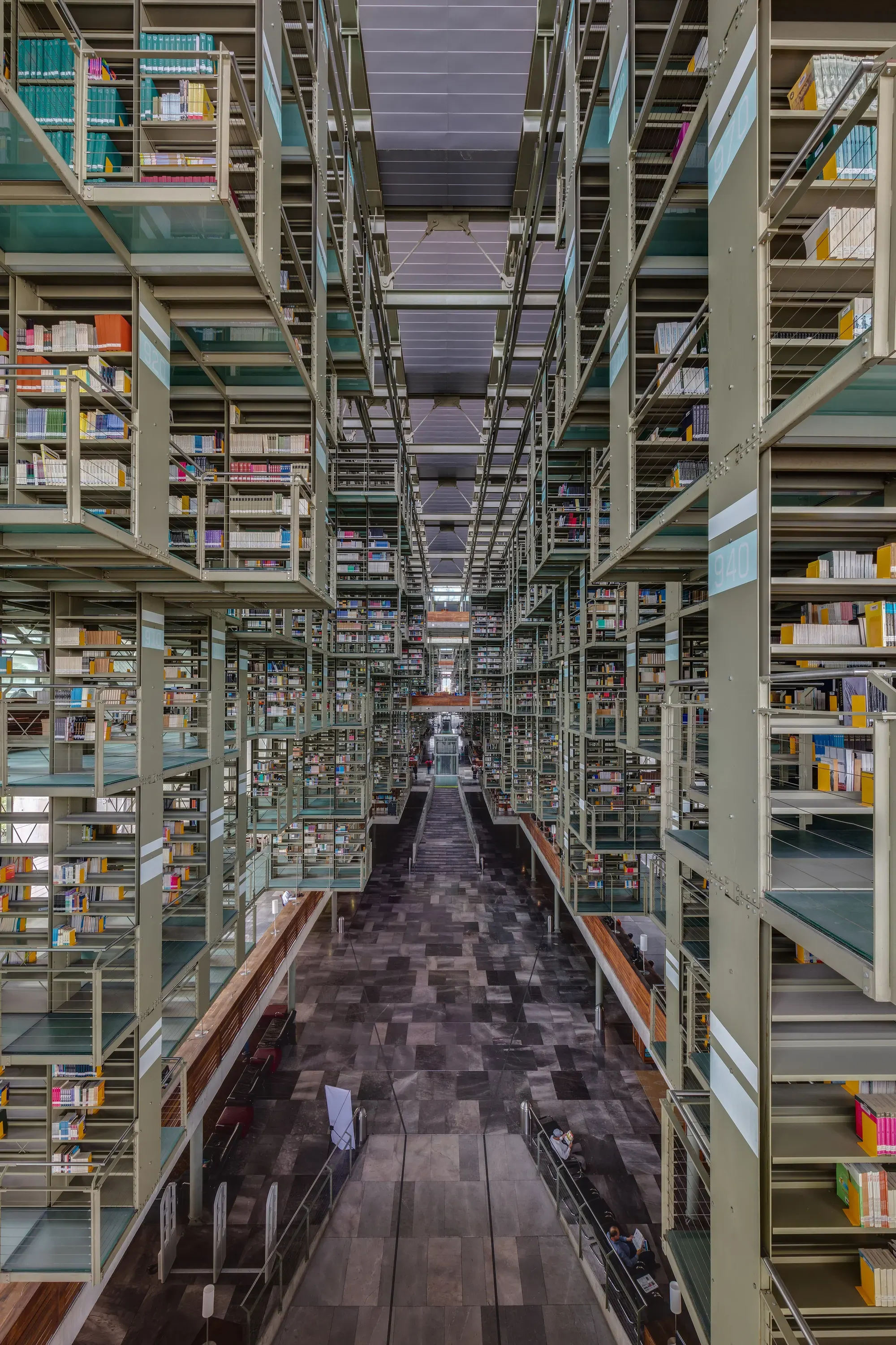 Steel bookshelves suspended in tiers across a vast atrium, linked by walkways